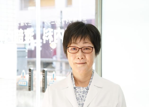 白衣姿で診療記録を手にした副院長のポートレート